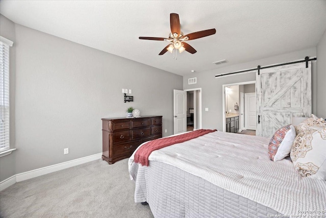 10218 Nate Range, San Antonio, TX 78254 - carpeted bedroom with a barn door, baseboards, a ceiling fan, and ensuite bath