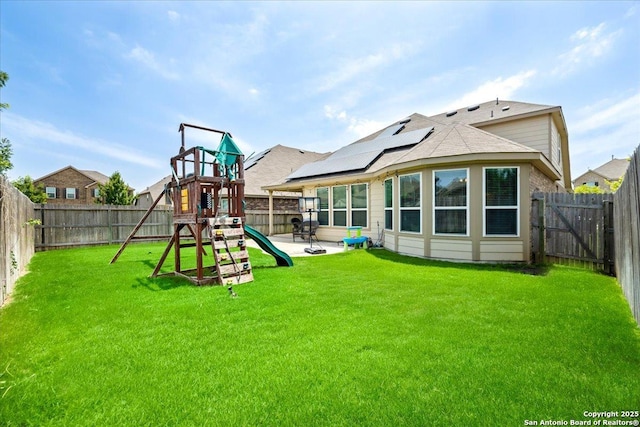 10218 Nate Range, San Antonio, TX 78254 - back of property with a playground, roof mounted solar panels, a patio area, and roof with shingles