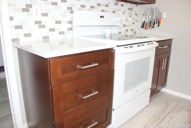 39 Latrobe Post, San Antonio, TX 78240 - kitchen featuring white range with electric stovetop, decorative backsplash, light countertops, light marble finish flooring, and baseboards