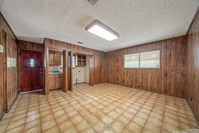 402 Waycrest, Windcrest, TX 78239 - spare room featuring wooden walls, a textured ceiling, and baseboards