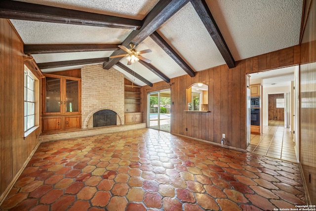 402 Waycrest, Windcrest, TX 78239 - unfurnished living room with a textured ceiling, wooden walls, ceiling fan, built in shelves, and a fireplace