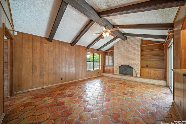 402 Waycrest, Windcrest, TX 78239 - unfurnished living room with a textured ceiling, wood walls, a ceiling fan, built in shelves, and a brick fireplace