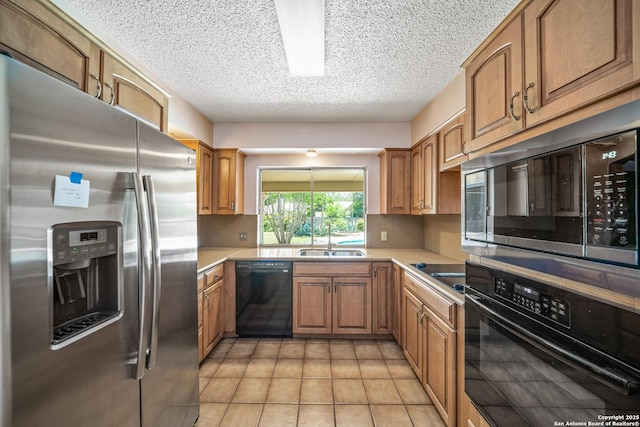 402 Waycrest, Windcrest, TX 78239 - kitchen with black appliances, a sink, a textured ceiling, light countertops, and brown cabinetry