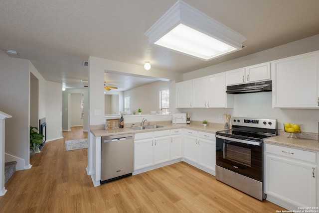 135 Agency Oaks, San Antonio, TX 78249 - kitchen featuring appliances with stainless steel finishes, under cabinet range hood, a sink, light wood-style flooring, and light countertops