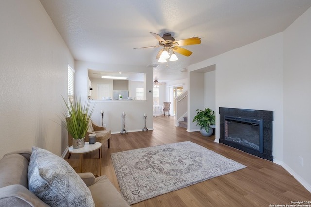 135 Agency Oaks, San Antonio, TX 78249 - living area with a ceiling fan, baseboards, stairs, wood finished floors, and a glass covered fireplace