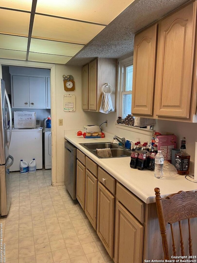 6823 S Whitland, San Antonio, TX 78239 - kitchen with a sink, stainless steel appliances, washing machine and dryer, light countertops, and light floors