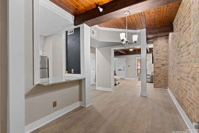 1170 Garraty Rd Unit 14, San Antonio, TX 78209 - unfurnished living room with brick wall, wooden ceiling with exposed beams, light wood finished floors, a chandelier, and baseboards