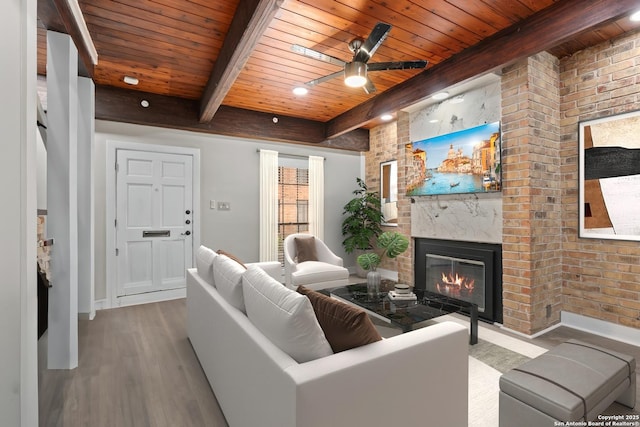 1170 Garraty Rd Unit 14, San Antonio, TX 78209 - living room with wooden ceiling with exposed beams, wood finished floors, a fireplace, a ceiling fan, and baseboards