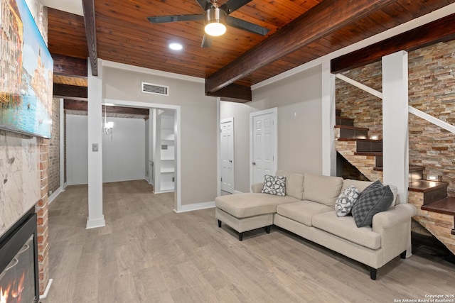 1170 Garraty Rd Unit 14, San Antonio, TX 78209 - living room with wooden ceiling with exposed beams, ceiling fan, light wood-type flooring, a fireplace, and baseboards