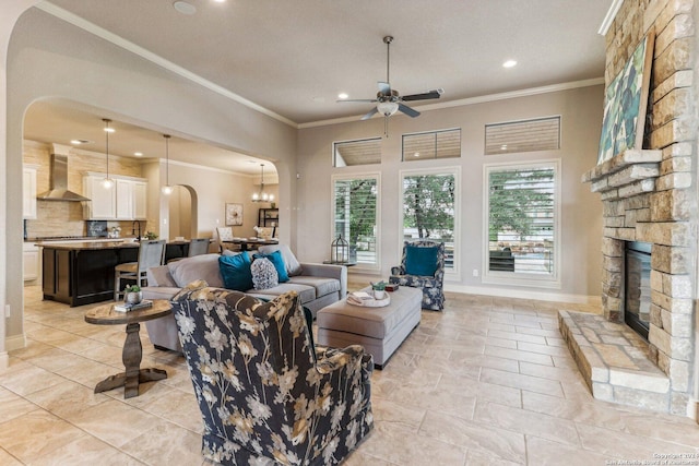 24227 Vecchio, San Antonio, TX 78260 - living area featuring arched walkways, ceiling fan, ornamental molding, a stone fireplace, and recessed lighting