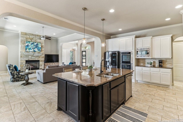 24227 Vecchio, San Antonio, TX 78260 - kitchen featuring a sink, arched walkways, appliances with stainless steel finishes, a ceiling fan, and dark stone countertops