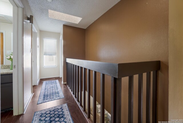 4107 Medical Dr Unit 2204, San Antonio, TX 78229 - hallway with a skylight, dark wood finished floors, and a textured ceiling