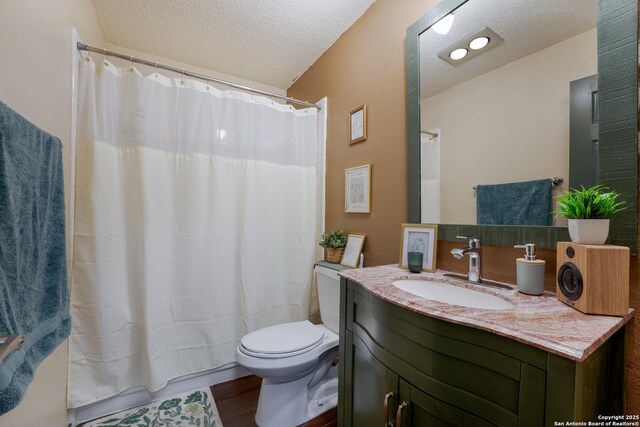 4107 Medical Dr Unit 2204, San Antonio, TX 78229 - full bathroom featuring toilet, a textured ceiling, vanity, wood finished floors, and a shower with curtain