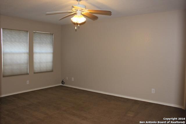 10047 Powderhouse Dr, San Antonio, TX 78239 - empty room featuring ceiling fan, dark carpet, and baseboards