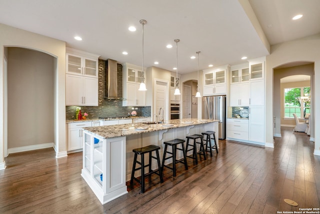 3122 Running Fawn, San Antonio, TX 78261 - kitchen featuring arched walkways, wall chimney exhaust hood, stainless steel appliances, a sink, and recessed lighting