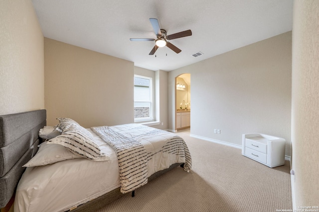 3122 Running Fawn, San Antonio, TX 78261 - bedroom featuring arched walkways, light colored carpet, baseboards, a ceiling fan, and ensuite bathroom