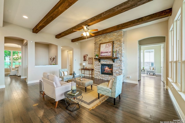 3122 Running Fawn, San Antonio, TX 78261 - living room with a fireplace, dark wood-style floors, arched walkways, ceiling fan, and beamed ceiling