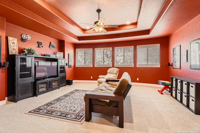 12424 Andice, Helotes, TX 78023 - living area featuring a raised ceiling, ceiling fan, carpet, a textured ceiling, and baseboards