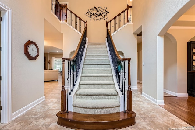 12424 Andice, Helotes, TX 78023 - stairway featuring arched walkways, a high ceiling, baseboards, and crown molding