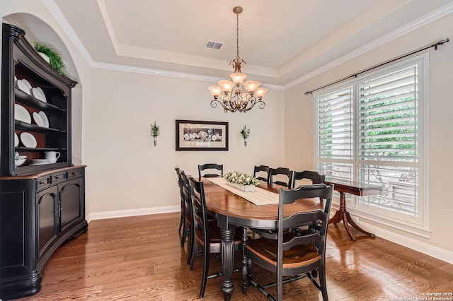 12424 Andice, Helotes, TX 78023 - dining room with a chandelier, a tray ceiling, wood finished floors, baseboards, and ornamental molding