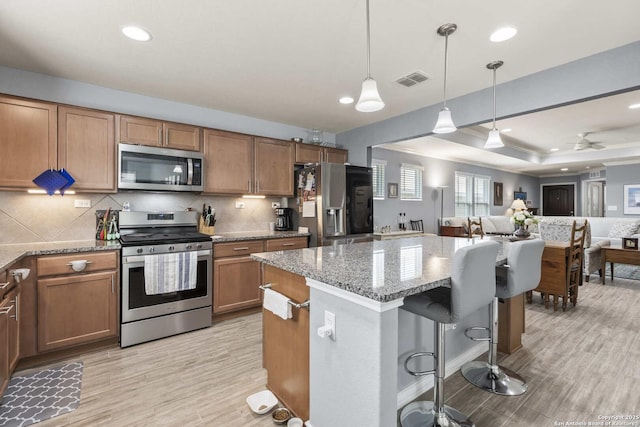 3402 Red Fls, San Antonio, TX 78253 - kitchen featuring appliances with stainless steel finishes, brown cabinets, light stone countertops, open floor plan, and recessed lighting