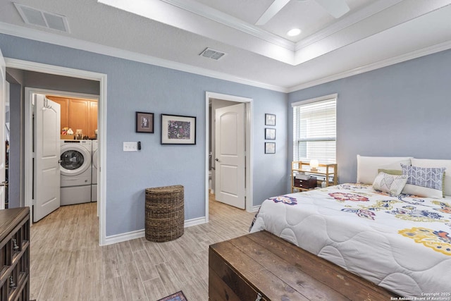 3402 Red Fls, San Antonio, TX 78253 - bedroom featuring washing machine and clothes dryer, light wood-style floors, crown molding, baseboards, and a raised ceiling