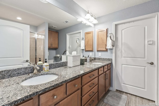 3402 Red Fls, San Antonio, TX 78253 - bathroom with double vanity, a stall shower, toilet, and wood finished floors