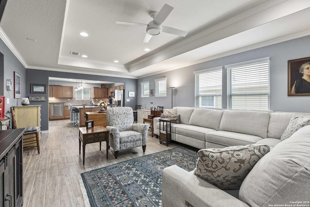3402 Red Fls, San Antonio, TX 78253 - living room with a raised ceiling, light wood finished floors, ornamental molding, a ceiling fan, and recessed lighting