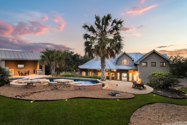 20402 Messina, San Antonio, TX 78258 - pool at dusk featuring an outdoor fire pit, a patio area, an outdoor pool, and a yard
