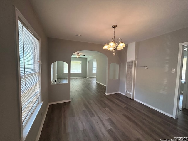 407 Westminster Ave, San Antonio, TX 78228 - unfurnished dining area featuring a heating unit, arched walkways, dark wood-type flooring, baseboards, and a chandelier