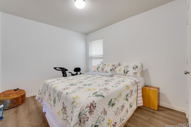 6022 Akin Pl, San Antonio, TX 78261 - bedroom featuring baseboards and wood finished floors
