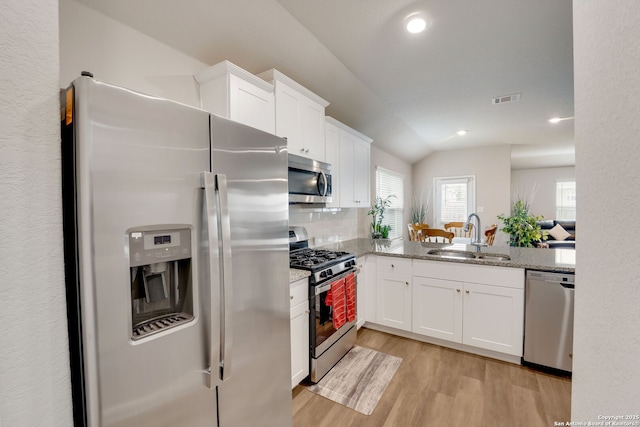 6022 Akin Pl, San Antonio, TX 78261 - kitchen with appliances with stainless steel finishes, a sink, light wood finished floors, white cabinets, and tasteful backsplash
