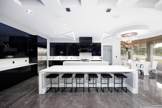 25003 Miranda Rdg, Boerne, TX 78006 - kitchen with modern cabinets, a chandelier, a kitchen bar, marble tiled floors, and a large island
