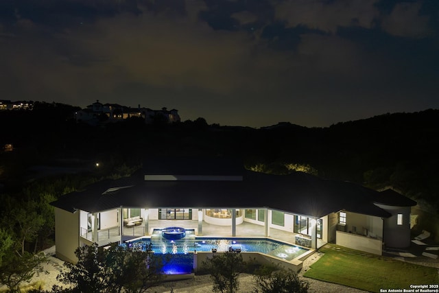 25003 Miranda Rdg, Boerne, TX 78006 - back of house at twilight featuring a patio area and a pool with connected hot tub