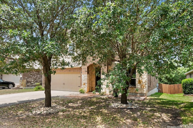 6031 Diego, San Antonio, TX 78253 - view of property hidden behind natural elements with driveway, a garage, stone siding, and brick siding