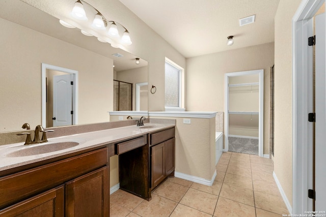 6031 Diego, San Antonio, TX 78253 - bathroom featuring double vanity, a garden tub, tile patterned floors, a walk in closet, and baseboards