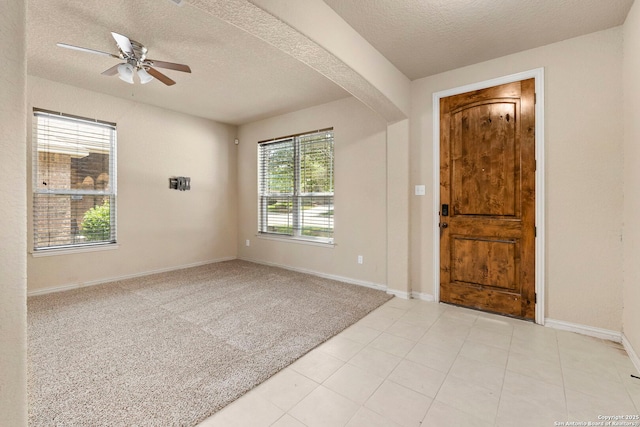 6031 Diego, San Antonio, TX 78253 - entrance foyer featuring a ceiling fan, baseboards, a textured ceiling, arched walkways, and light colored carpet