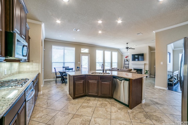 4522 Amos Pollard, San Antonio, TX 78253 - kitchen featuring appliances with stainless steel finishes, a sink, crown molding, an island with sink, and a fireplace