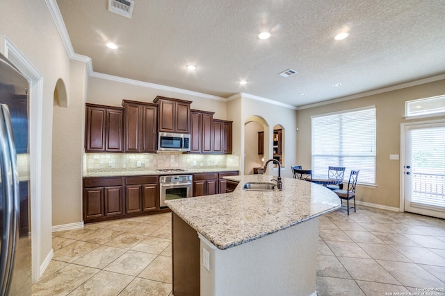 4522 Amos Pollard, San Antonio, TX 78253 - kitchen featuring a sink, arched walkways, stainless steel appliances, backsplash, and an island with sink