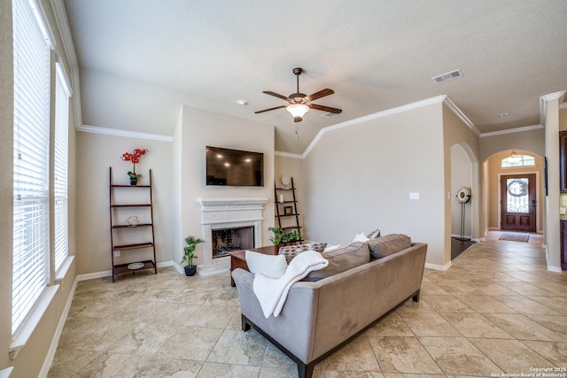 4522 Amos Pollard, San Antonio, TX 78253 - living area with arched walkways, plenty of natural light, a fireplace with raised hearth, and ornamental molding