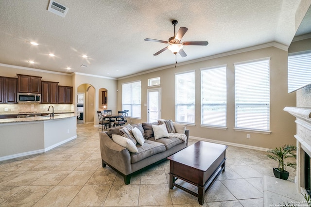 4522 Amos Pollard, San Antonio, TX 78253 - living area with arched walkways, a ceiling fan, plenty of natural light, crown molding, and a textured ceiling