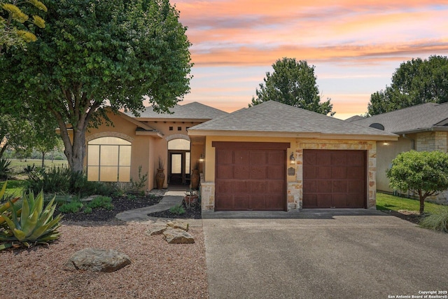 2756 Indian Wls, Kerrville, TX 78028 - view of front of home with stone siding, an attached garage, driveway, and stucco siding