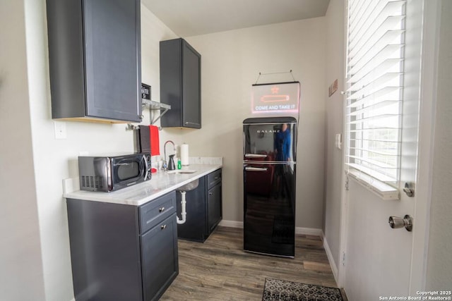 239 Damar Cv, Canyon Lake, TX 78133 - kitchen featuring black appliances, a sink, light countertops, wood finished floors, and baseboards