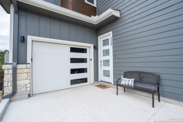 239 Damar Cv, Canyon Lake, TX 78133 - view of exterior entry featuring board and batten siding and a garage