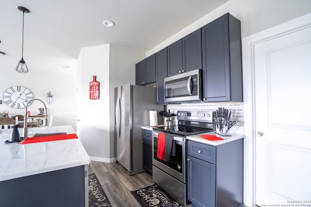 239 Damar Cv, Canyon Lake, TX 78133 - kitchen with stainless steel appliances, dark wood-type flooring, decorative light fixtures, a sink, and tasteful backsplash
