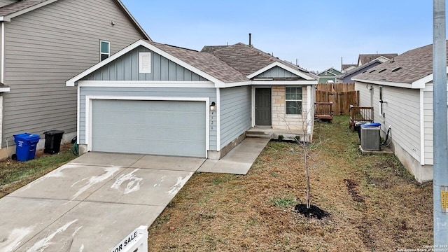 4526 Meadowland, San Antonio, TX 78222 - view of front of house with an attached garage, central air condition unit, driveway, board and batten siding, and a shingled roof