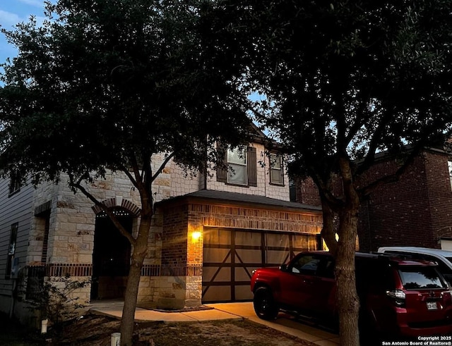 9819 Hawk Shr, Converse, TX 78109 - view of front facade with a garage, stone siding, driveway, and brick siding