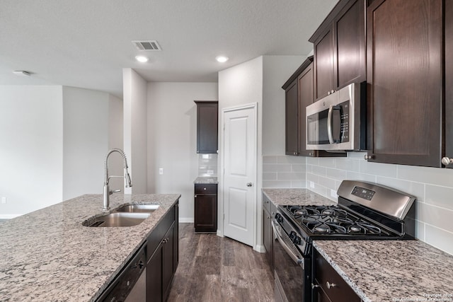 9003 La Garde Ml, San Antonio, TX 78254 - kitchen with appliances with stainless steel finishes, a sink, dark wood finished floors, light stone countertops, and dark brown cabinetry
