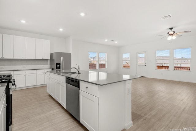 31908 Native Sun, Bulverde, TX 78163 - kitchen featuring appliances with stainless steel finishes, ceiling fan, light wood-type flooring, backsplash, and a center island with sink