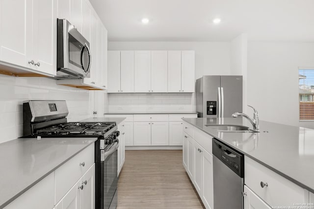 31908 Native Sun, Bulverde, TX 78163 - kitchen with appliances with stainless steel finishes, a sink, white cabinets, tasteful backsplash, and light wood-style flooring